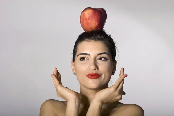 Donna che tiene una mela in testa Foto Stock Royalty Free