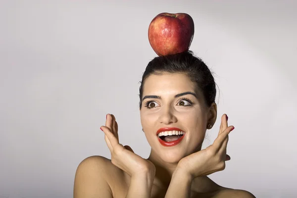 Žena drží jablko na hlavu Royalty Free Stock Obrázky