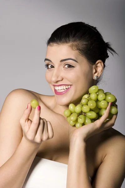 Frau mit frischen grünen Trauben lizenzfreie Stockfotos