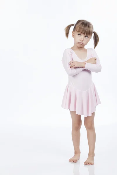 Расстроенная маленькая девочка в розовом наряде — стоковое фото