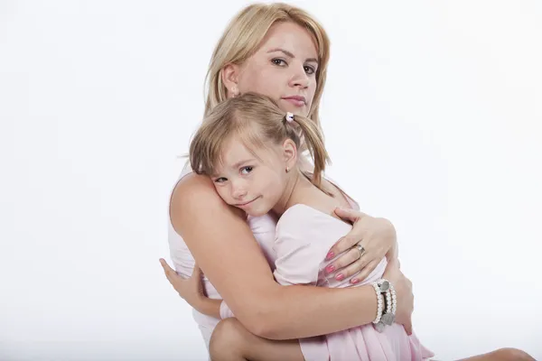 Unga vackra mamma kramar hennes sorgliga lilla dotter — Stockfoto