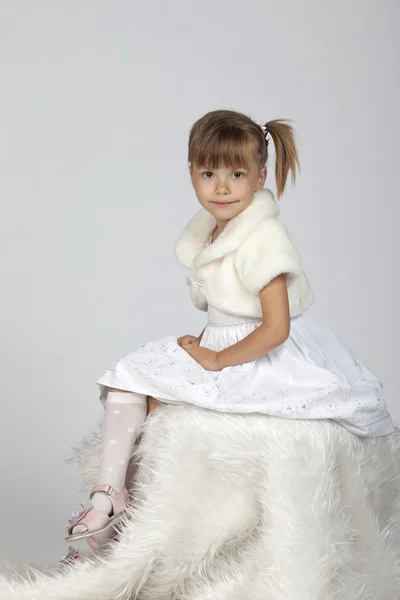 Студийное изображение красивой маленькой девочки в зимней настройке — стоковое фото