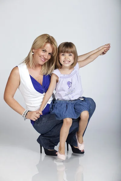 Joyful jovem mãe e filha em estúdio — Fotografia de Stock