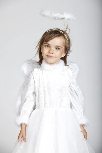 Χαριτωμένο κοριτσάκι ντυμένος ως ένας άγγελος με λευκό φόρεμα και φωτοστέφανο — Φωτογραφία Αρχείου