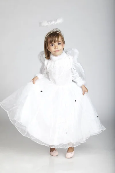 Очаровательная 5-летняя девочка, одета в костюм ангела с крыльями и нимбом — стоковое фото