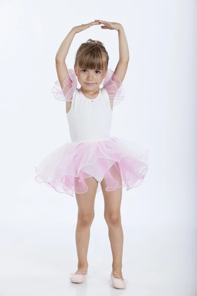 Счастливая маленькая балерина, изучающая новую позицию в балете — стоковое фото