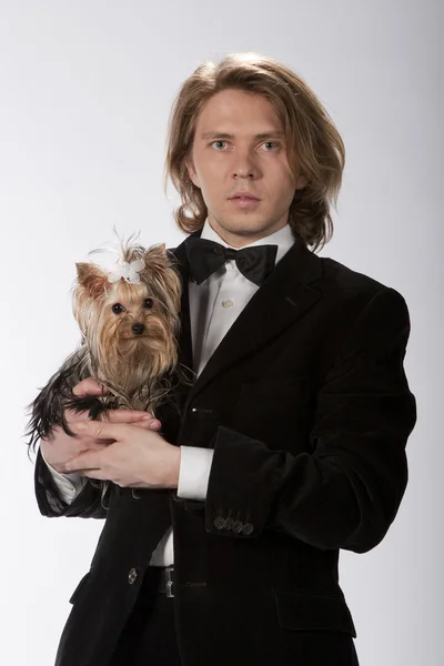 Elegant gentleman holding his cute puppy — Stock Photo, Image