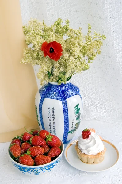 Fresas, tarta y un jarrón con flores —  Fotos de Stock