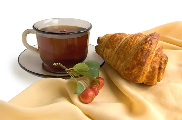 Kahverengi cam bardak çay ve kruvasan ile — Stok fotoğraf