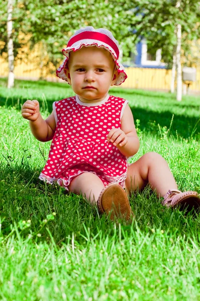 Ευτυχισμένη κοριτσάκι σε έναν χορτοτάπητα — Φωτογραφία Αρχείου