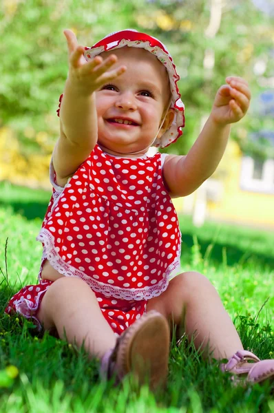 Bir çim üzerinde mutlu küçük kız — Stok fotoğraf