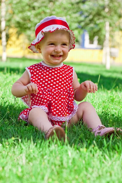 Счастливая маленькая девочка на лужайке — стоковое фото