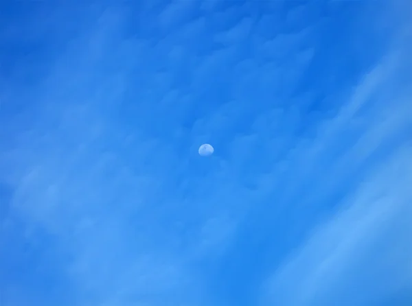 Moon on blue sky with many clouds — Stock Photo, Image