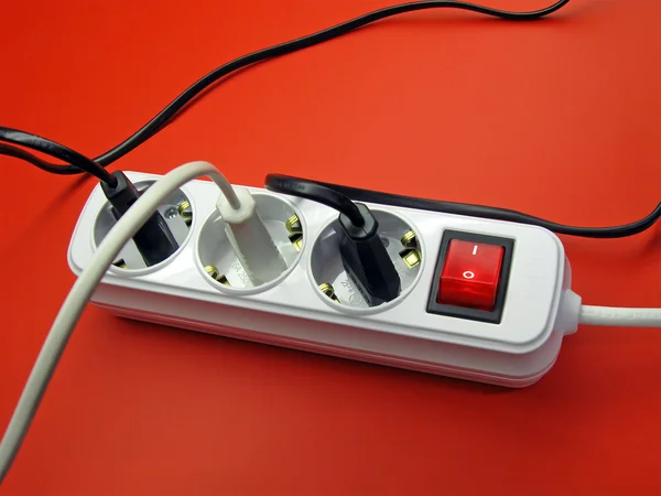 Pilha de fios em soquete, fundo vermelho — Fotografia de Stock