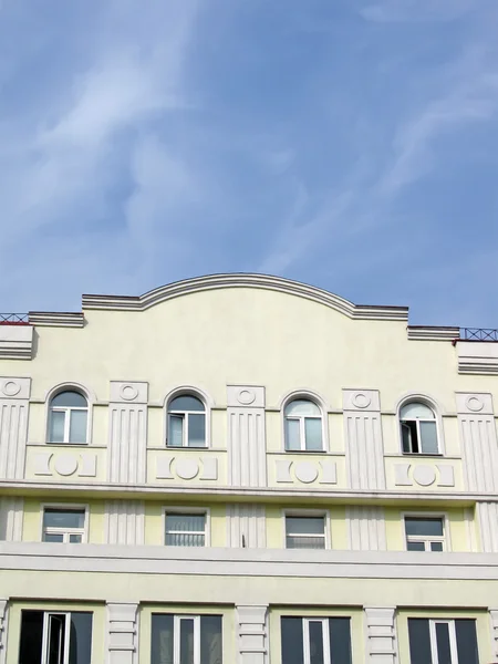 Yellow building, round windows, blue sky — Stock Photo, Image