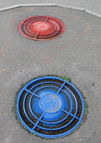 Red, blue street cover, sewerpipe — Stock Photo, Image