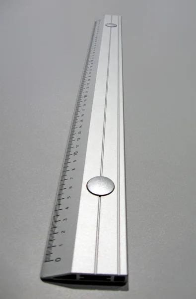 Серебряная металлическая линейка на металлической поверхности — стоковое фото