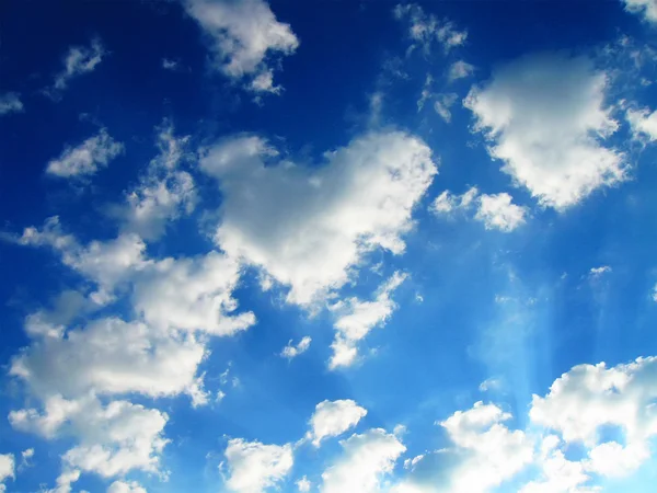 Beyaz bulutların üzerinde mavi gök, güneş ışınları, hava durumu — Stok fotoğraf