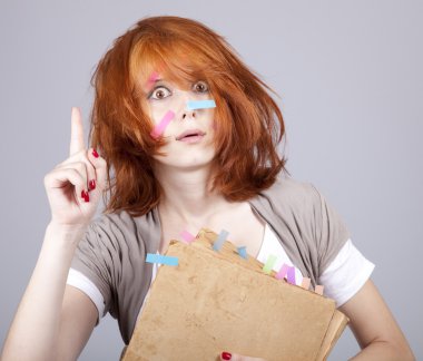 Red-haired student with book and notes on face. clipart