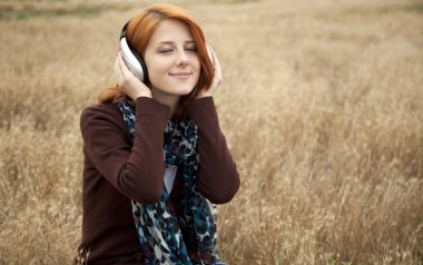 jonge glimlachend mode met koptelefoon op veld.