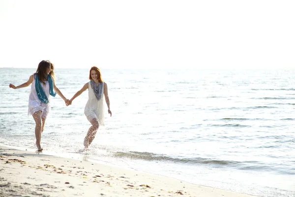 两个美丽的女孩，在沙滩上运行. — 图库照片
