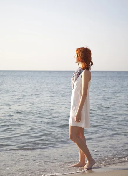 Όμορφη κοκκινομάλλα κοπέλα με την Ανατολή στην παραλία. — Φωτογραφία Αρχείου