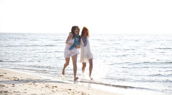 Duas meninas bonitas correndo na praia . — Fotografia de Stock
