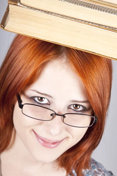 Kızıl saçlı kız kitaplar başını tutun. Stüdyo vurdu. — Stok fotoğraf