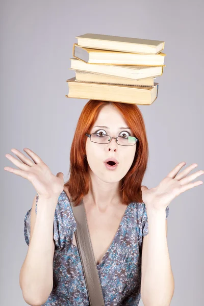 Κοκκινομάλλης κορίτσι κρατήστε τα βιβλία στο κεφάλι της. Studio που γυρίστηκε. — Φωτογραφία Αρχείου