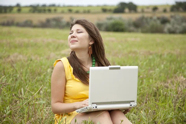 Jeune belle fille avec ordinateur portable sur le terrain — Photo