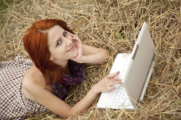 Jeune fille de mode avec ordinateur portable couché sur le terrain — Photo