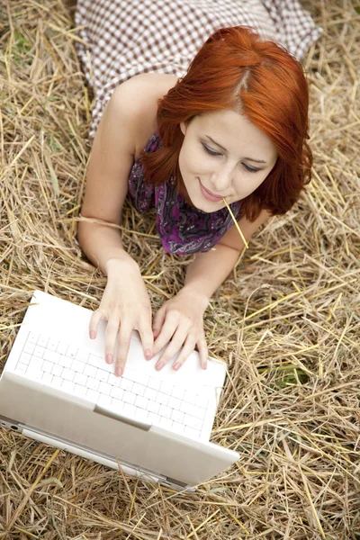 Jonge mode meisje met laptop liggen op veld — Stockfoto