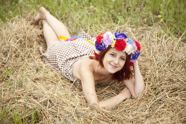 Девушка в славянском национальном венке лежит на поле . — стоковое фото