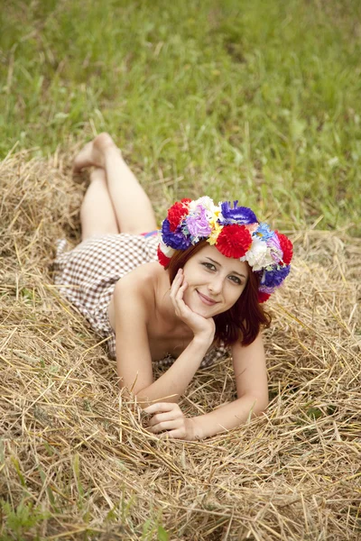 Girl in Slav national wreath lying at field. — Stock Photo, Image