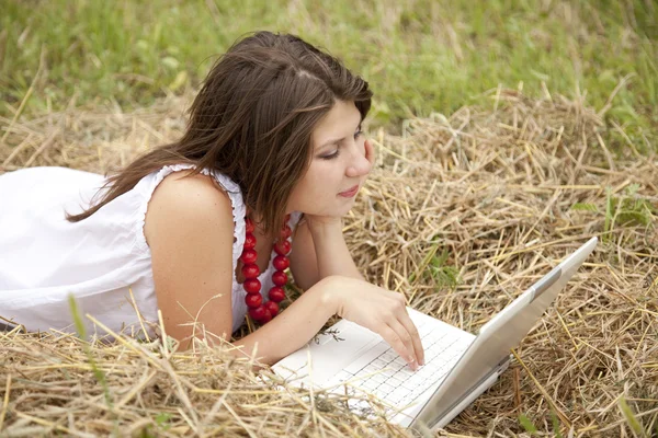 Mladá móda dívka s notebookem na poli — Stock fotografie