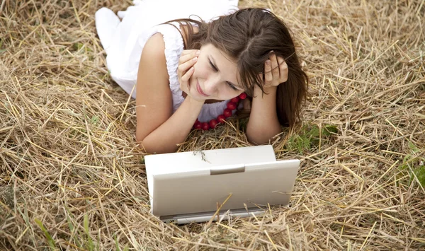 Giovane ragazza di moda con taccuino sdraiato sul campo — Foto Stock