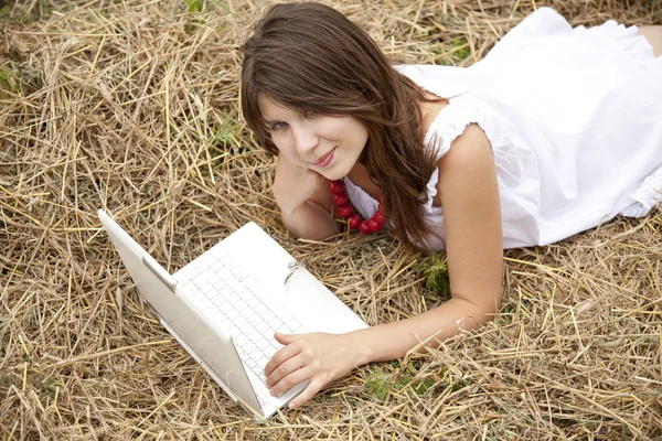 Chica de la moda joven con cuaderno acostado en el campo — Foto de Stock