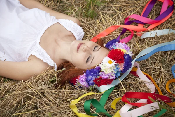 Slav girl with wreath lying at field — Stock Photo, Image