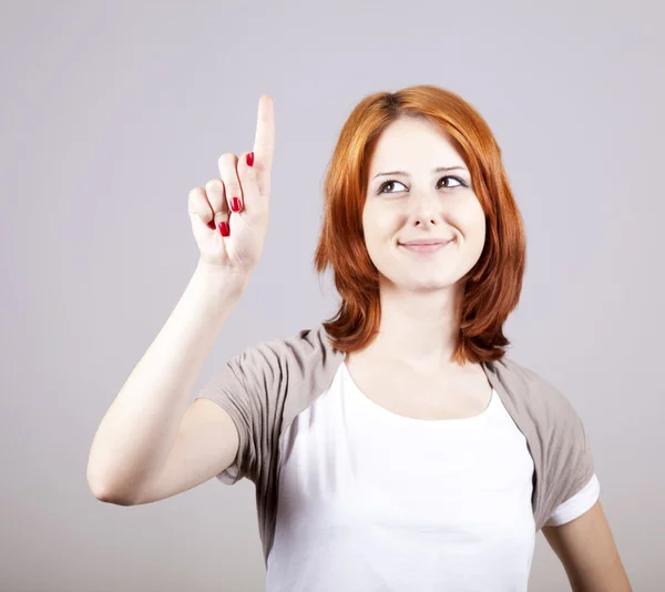 Рыжая деловая женщина показывает пальцем что-то в воздухе . — стоковое фото