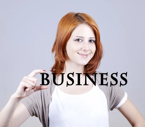Rudowłosa bizneswoman pokazać abstrakcyjne słowo "biznes". — Zdjęcie stockowe