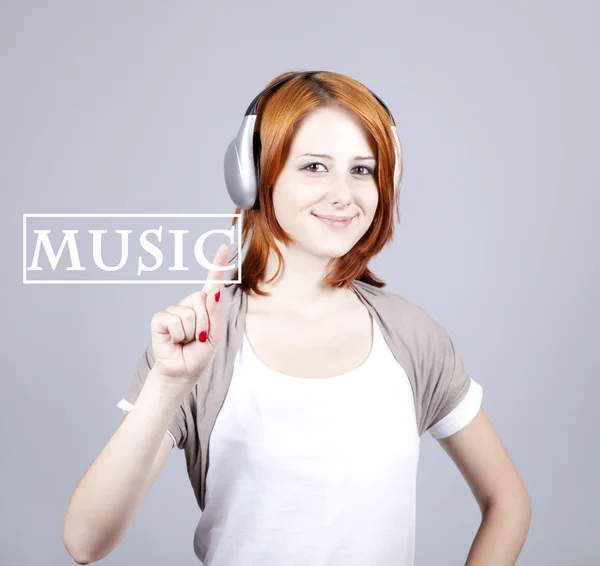 Girl with modern headphones push abstract "music" button. — Stock Photo, Image