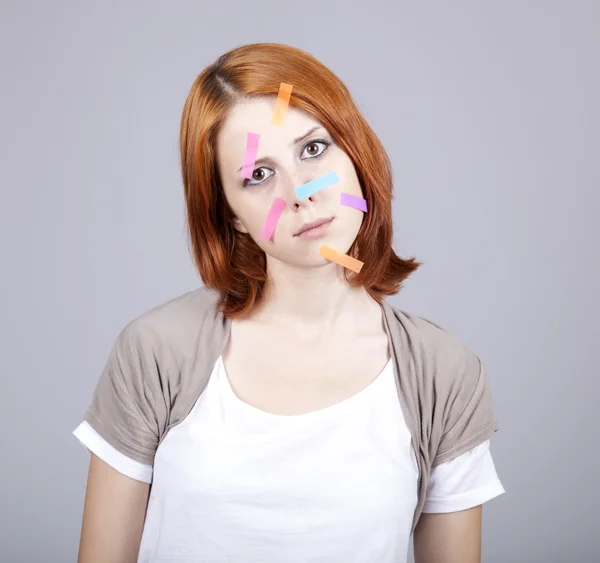 Red-haired student with notes on face. — Stock Photo, Image