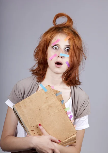 Rothaarige Studentin mit Buch und Notizen im Gesicht. — Stockfoto
