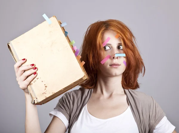 Roodharige zakenvrouw met boek en notities op gezicht. — Stockfoto