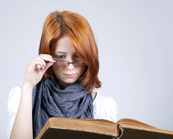 Joven chica de moda dudando en gafas con libro viejo —  Fotos de Stock