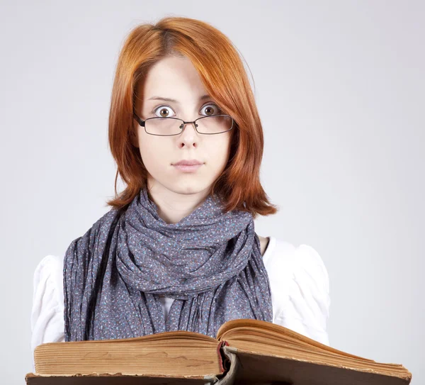 Joven chica de moda dudando en gafas con libro viejo —  Fotos de Stock
