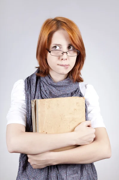 Joven chica de moda dudando en gafas con libro viejo — Foto de Stock