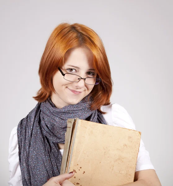 Mladý usmívající se móda dívka v brýlích s staré knihy — Stock fotografie