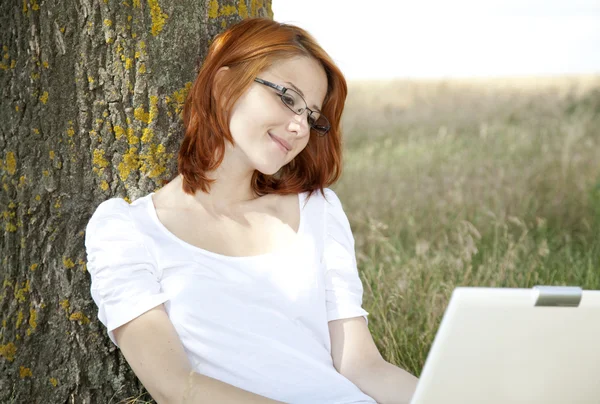 Jeunes femmes d'affaires en blanc avec des lunettes et ordinateur portable assis nea — Photo