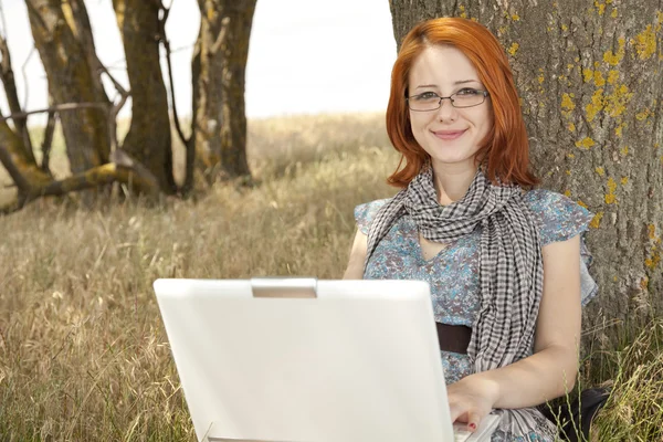Jonge mode meisje in glazen en laptop zitten in de buurt van — Stockfoto